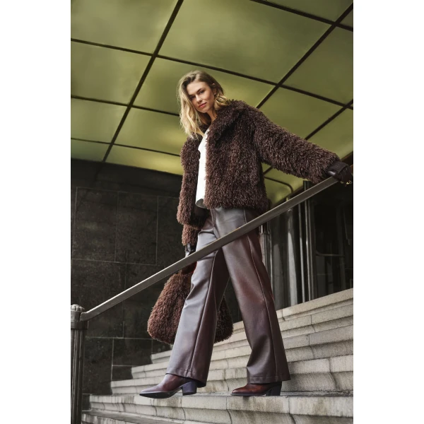 Model wearing Rino & Pelle Lias faux fur jacket in Chocolate styled with wide leg trousers