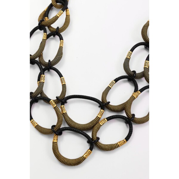 Close-up of Naya black and gold statement necklace with textured linked loop design