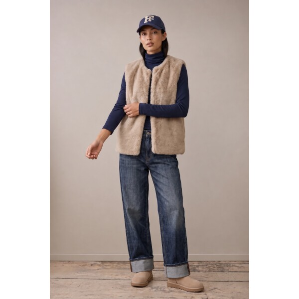Woman wearing Fynch Hatton Neutral Tan faux fur gilet with navy roll neck and jeans